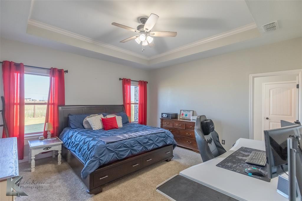 138 Lisa Lane Tuscola, TX 79562 - Photo 19 of 38 a bedroom with a bed and a chandelier