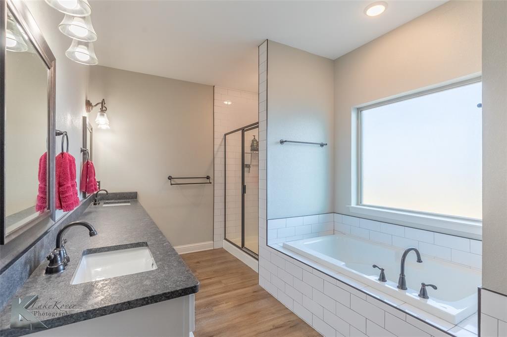 138 Lisa Lane Tuscola, TX 79562 - Photo 22 of 38 a bathroom with a granite countertop sink and a tub
