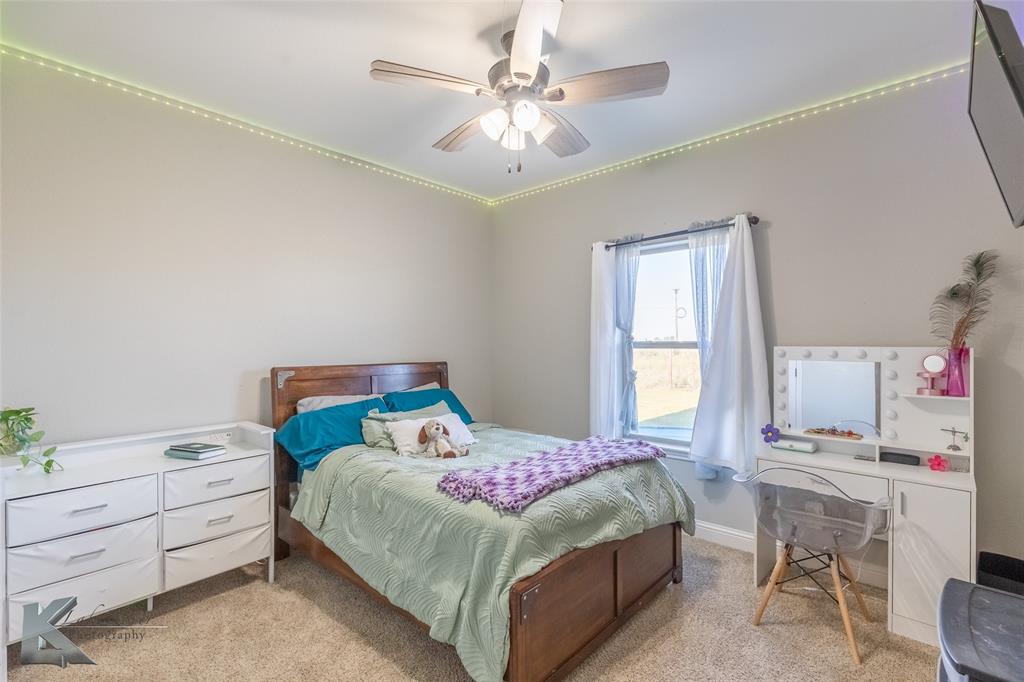 138 Lisa Lane Tuscola, TX 79562 - Photo 28 of 38 a bedroom with a bed and a chandelier