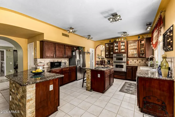 a kitchen with stainless steel appliances granite countertop a stove a sink dishwasher and a refrigerator