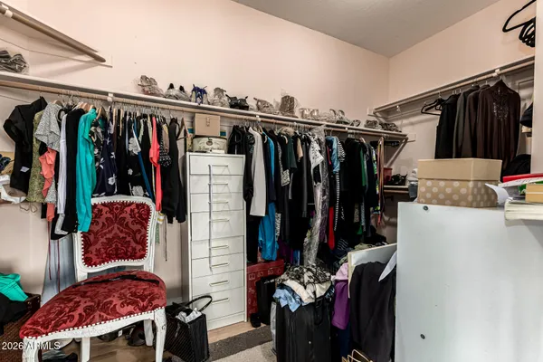 a view of walk in closet with clothes and shoes
