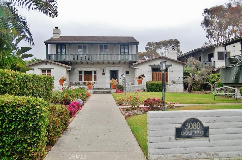 a front view of a house with a yard and potted plants