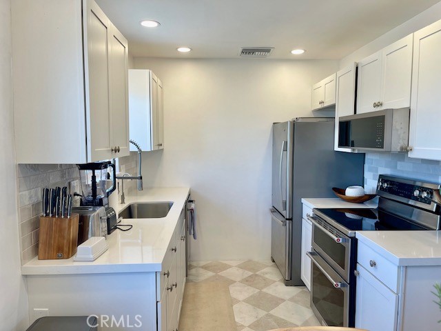 3080 Lincoln Street, Unit 17 Carlsbad, CA 92008 - Photo 11 of 26 a kitchen that has a sink cabinets counter space and stainless steel appliances