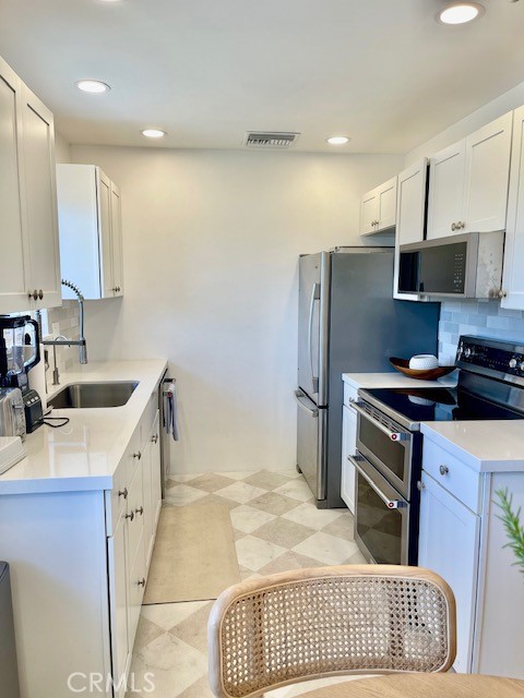 3080 Lincoln Street, Unit 17 Carlsbad, CA 92008 - Photo 12 of 26 a kitchen with a sink stove and refrigerator