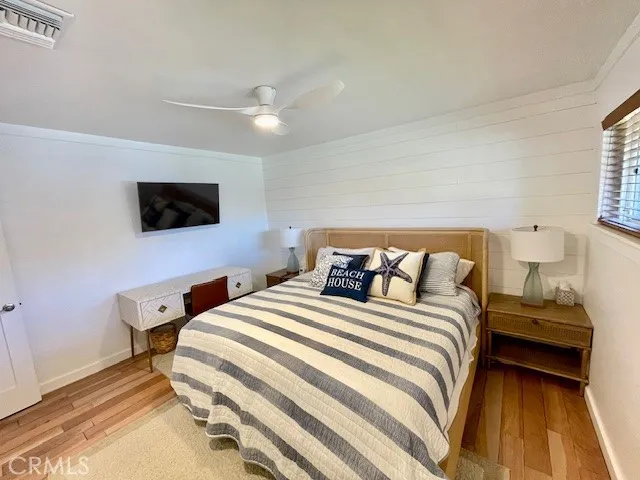 a bedroom with a bed and a flat tv screen on dresser