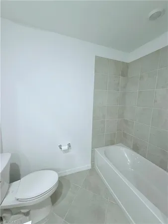 a white toilet sitting next to a bath tub