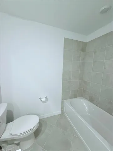 a white toilet sitting next to a bath tub
