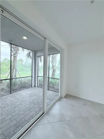 a view of an empty room with wooden floor and windows