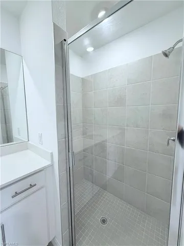 a bathroom with a shower and a sink a mirror