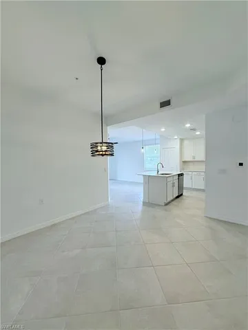 a kitchen with stainless steel appliances a refrigerator a sink a stove a microwave and white cabinets