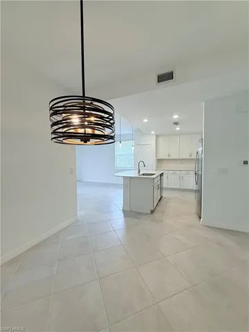 a view of a kitchen with a sink and a chandelier fan