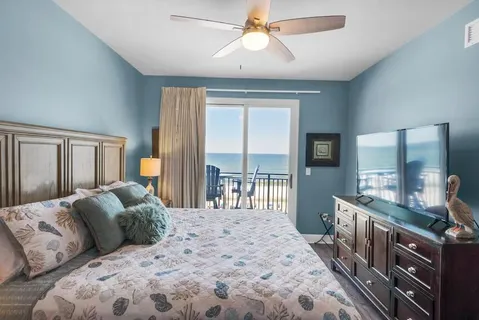 a bedroom with a large bed and a flat tv screen on dresser