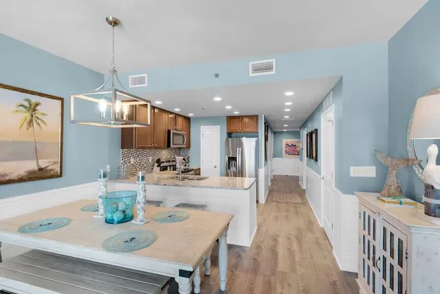 a dining room with stainless steel appliances furniture a window and kitchen view