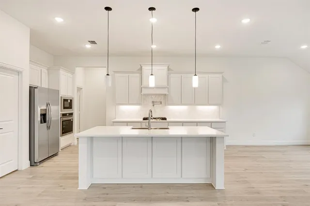 a view of a kitchen with kitchen island a counter space appliances and a ceiling cabinets