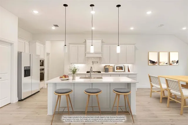 a kitchen with stainless steel appliances kitchen island granite countertop a table chairs and white cabinets