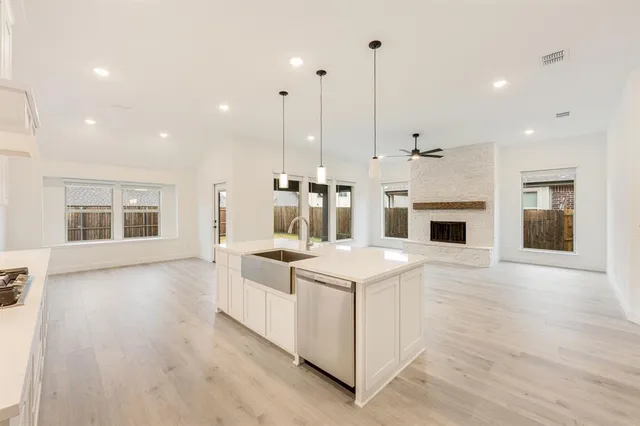 a kitchen with stainless steel appliances kitchen island a stove a refrigerator a oven and a wooden floors