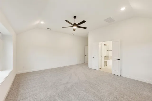 an empty room with closet and a ceiling fan