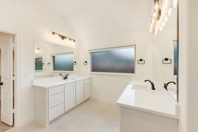 a bathroom with a double vanity sink and mirror