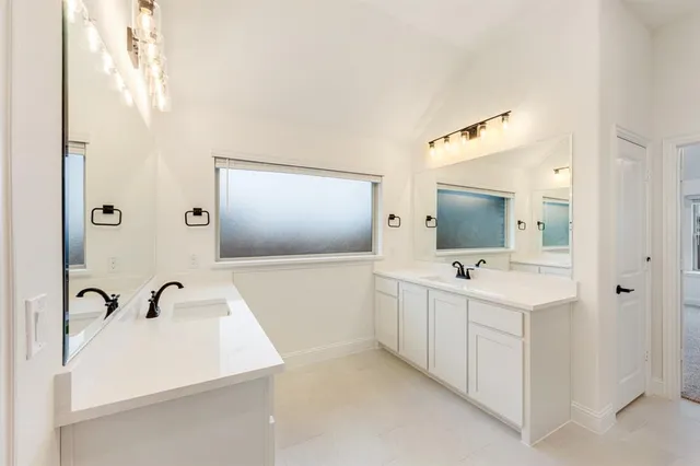 a bathroom with a double vanity sink and mirror