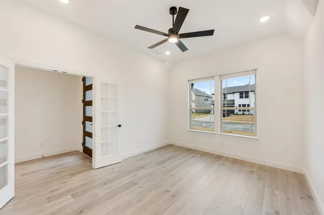 a view of a livingroom with wooden floor and a ceiling fan