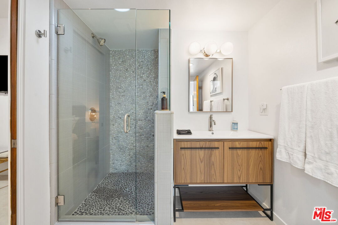 1414 Sagebrush Road Palm Springs, CA 92264 - Photo 33 of 48 a bathroom with a sink a mirror and a shower
