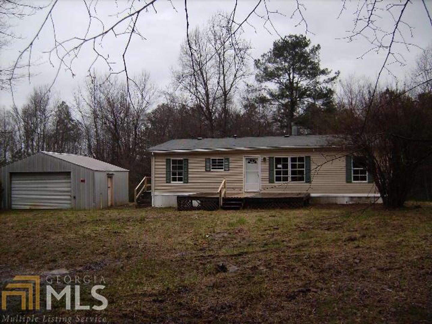 1014 10 Oaks Road Buchanan, GA 30113 - Photo 1 of 1 a house that is sitting in the grass with large trees