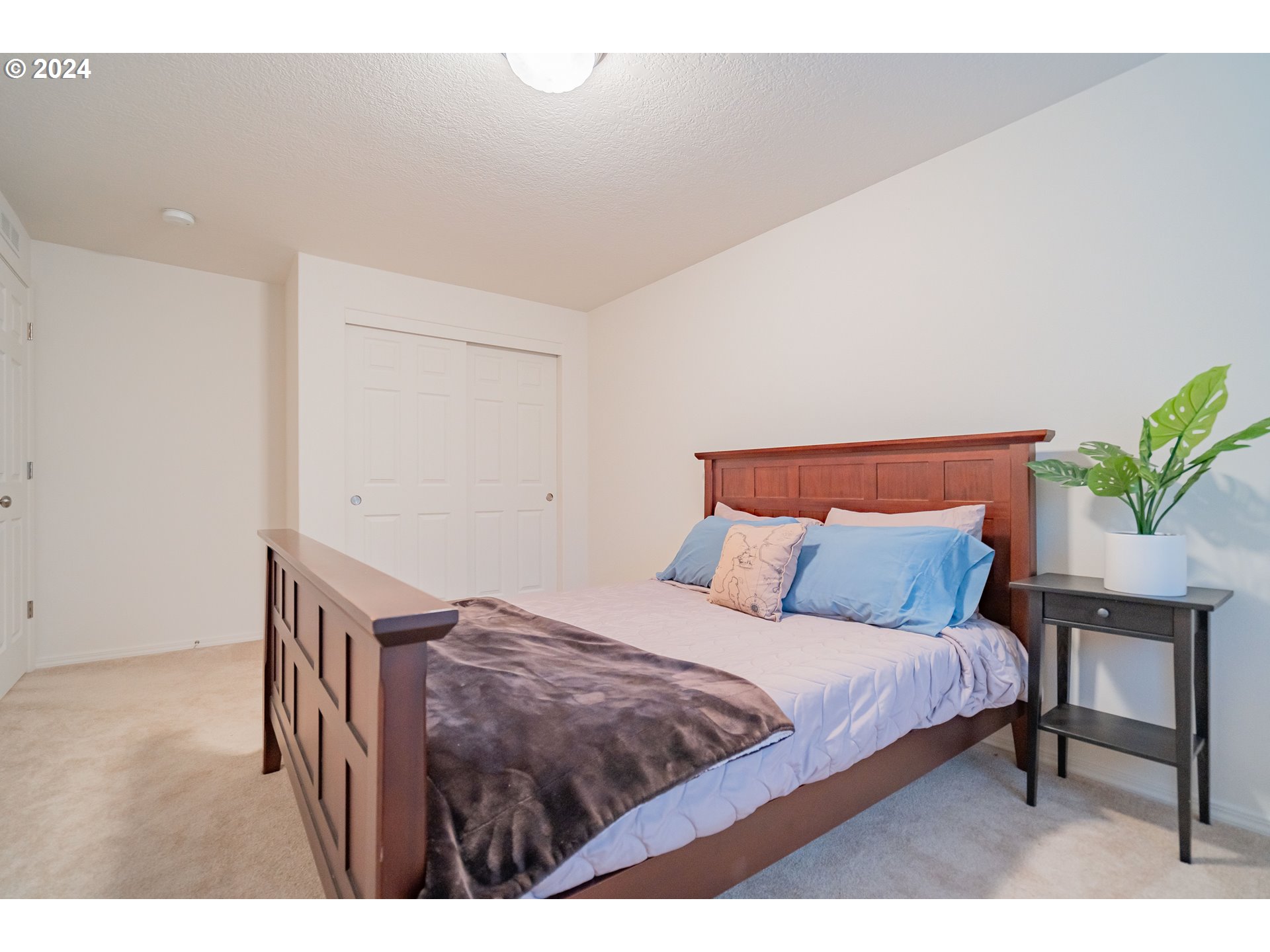 1420 Southeast 5th Way Battle Ground, WA 98604 - Photo 23 of 32 a bedroom with a bed a table and potted plant