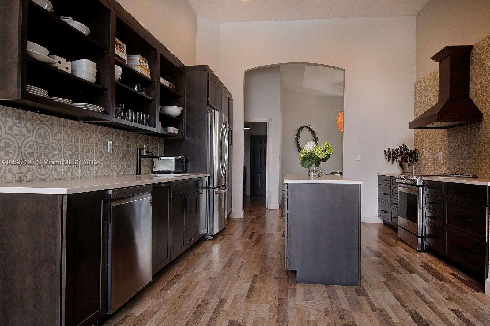 541 Ranch Road Weston, FL 33326 - Photo 11 of 41 a kitchen with stainless steel appliances granite countertop a refrigerator a stove and a wooden floors
