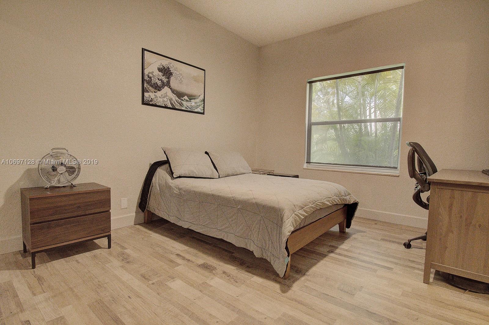 541 Ranch Road Weston, FL 33326 - Photo 26 of 41 a bedroom with a bed and wooden floor