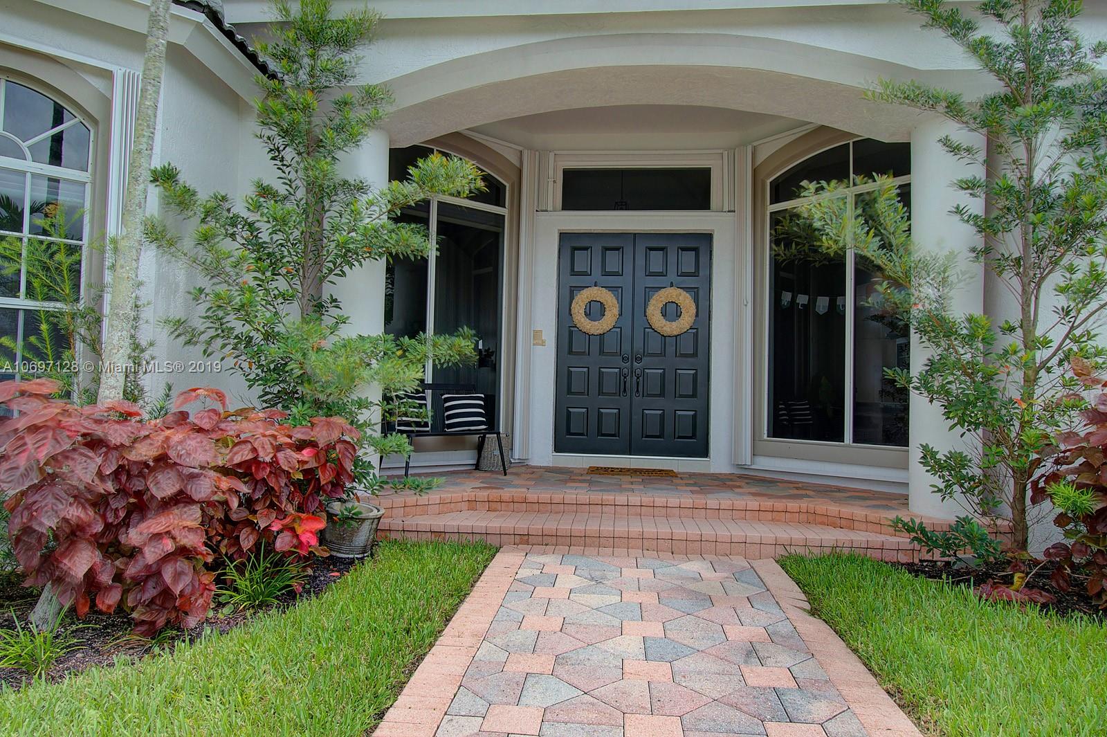 541 Ranch Road Weston, FL 33326 - Photo 3 of 41 a front view of a house with garden