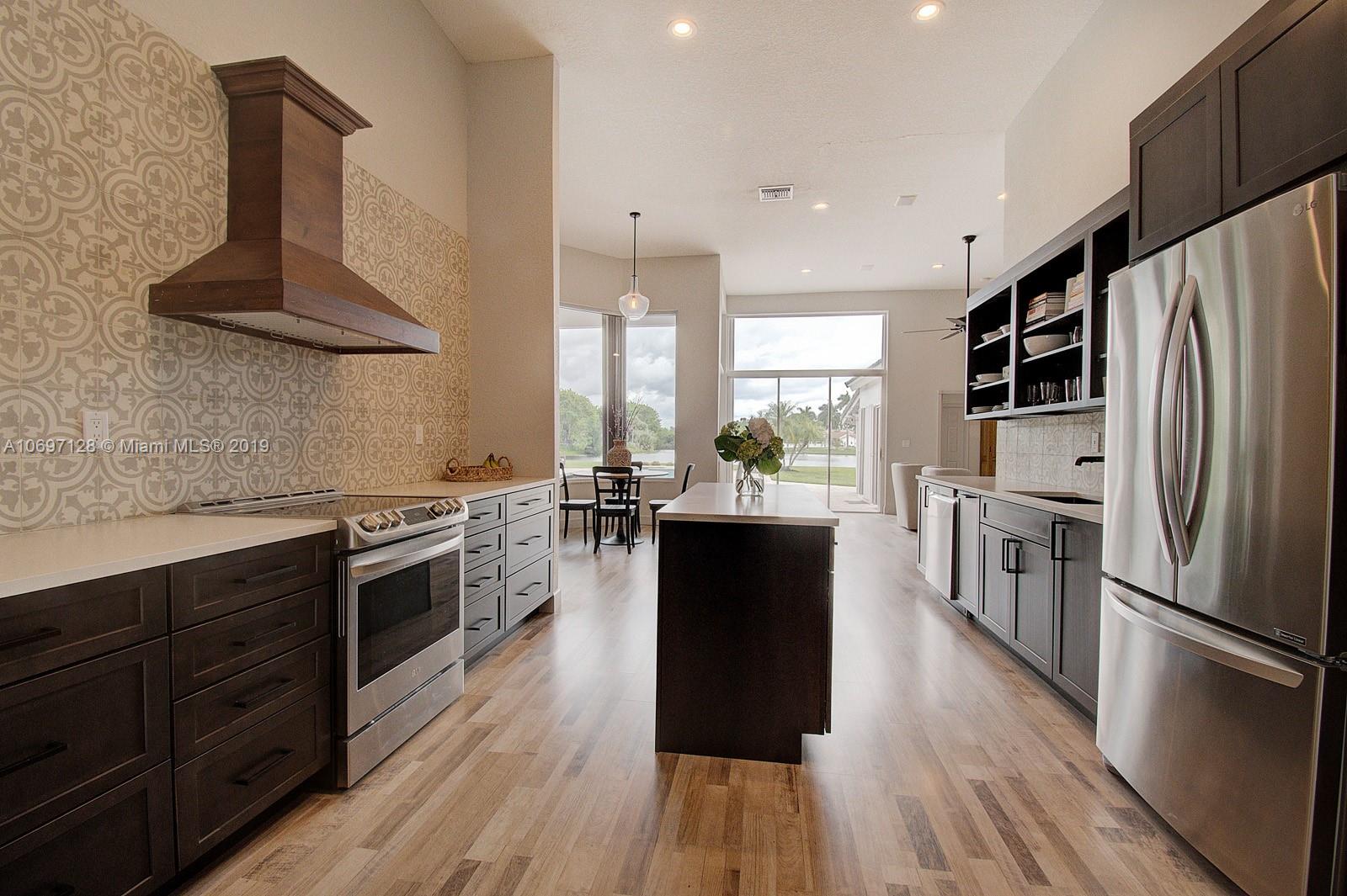 541 Ranch Road Weston, FL 33326 - Photo 10 of 41 a kitchen with stainless steel appliances a stove a sink a refrigerator and wooden floor