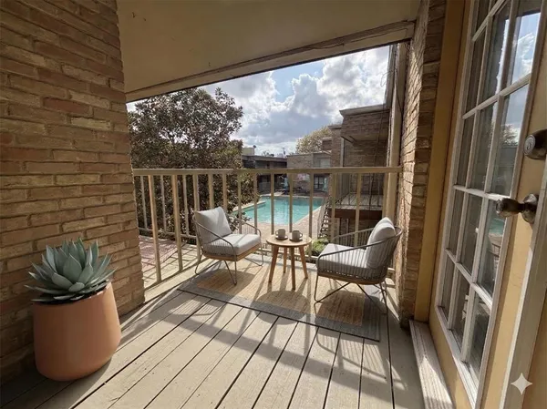 a view of a balcony with chairs and wooden floor