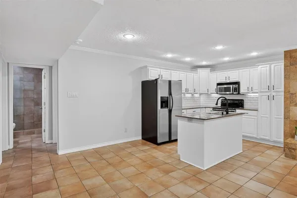 a kitchen with stainless steel appliances granite countertop a refrigerator sink and microwave