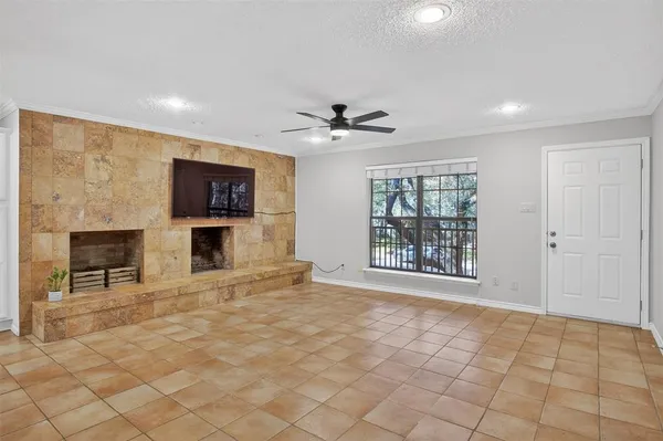 a view of an empty room with a fireplace and a window