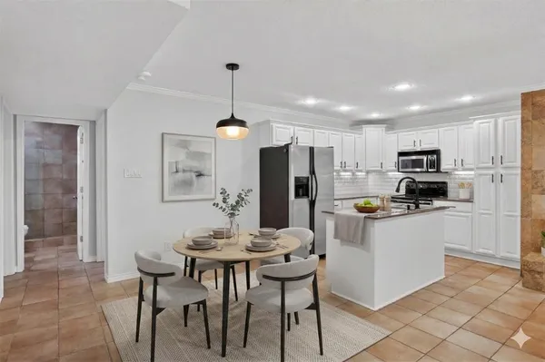 a kitchen with a refrigerator a stove a sink a dining table and chairs