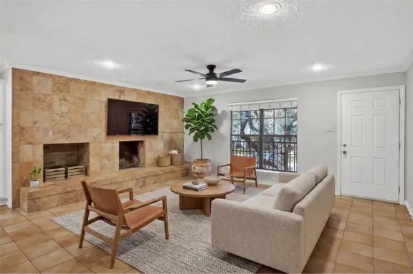 a living room with furniture a fireplace and a flat screen tv