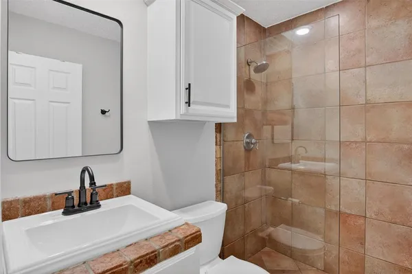 a bathroom with a sink a toilet and shower