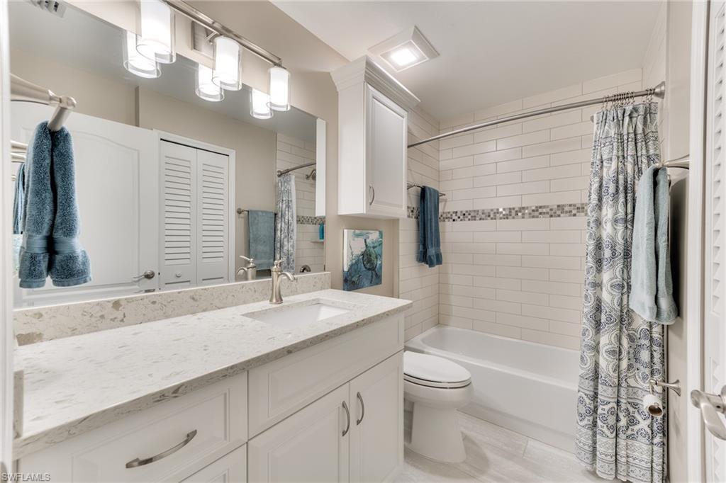 9281 Spring Run Boulevard, Unit 2602 Estero, FL 34135 - Photo 29 of 36 a bathroom with a granite countertop sink toilet and shower