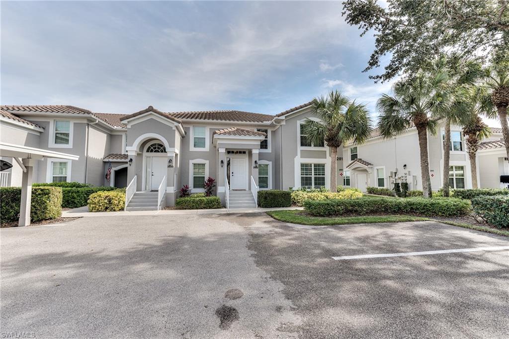 9281 Spring Run Boulevard, Unit 2602 Estero, FL 34135 - Photo 32 of 36 a front view of a house with a yard and potted plants