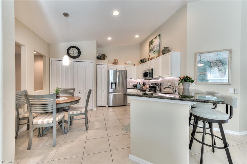 9281 Spring Run Boulevard, Unit 2602 Estero, FL 34135 - Photo 10 of 36 a kitchen with stainless steel appliances kitchen island granite countertop a sink and cabinets