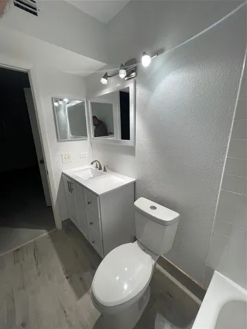 a bathroom with a sink a toilet and mirror