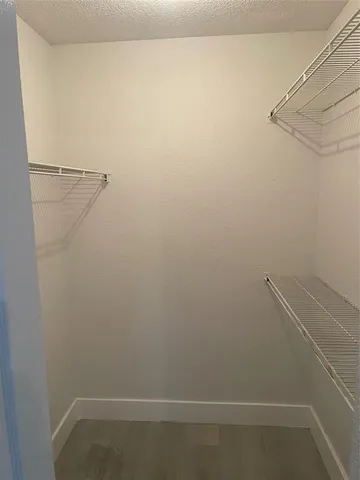 an empty room with a window and a ceiling fan