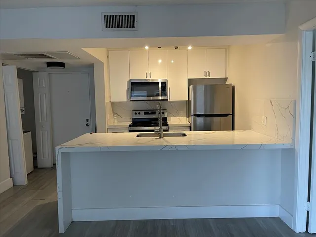 a kitchen with a refrigerator and a stove top oven