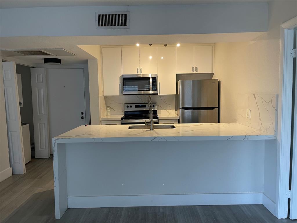 8100 Geneva Court, Unit 535 Doral, FL 33166 - Photo 20 of 27 a kitchen with stainless steel appliances a refrigerator and a stove top oven