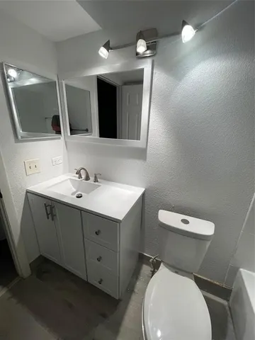 a bathroom with a toilet sink and mirror