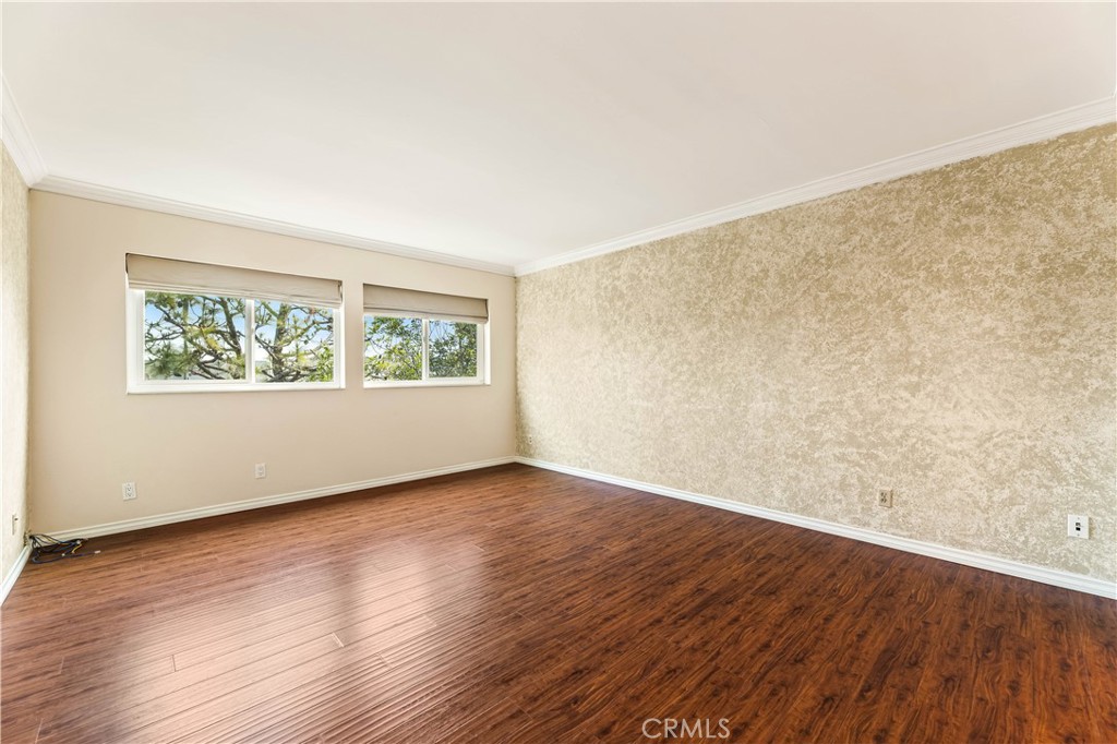 12300 Montecito Road, Unit 42 Seal Beach, CA 90740 - Photo 27 of 44 a view of an empty room with wooden floor and a window
