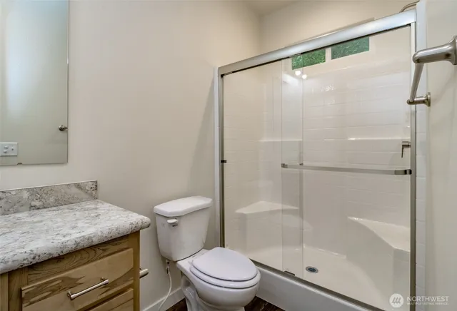 a bathroom with a granite countertop sink toilet and shower