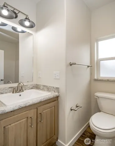 a bathroom with a granite countertop sink toilet and a mirror