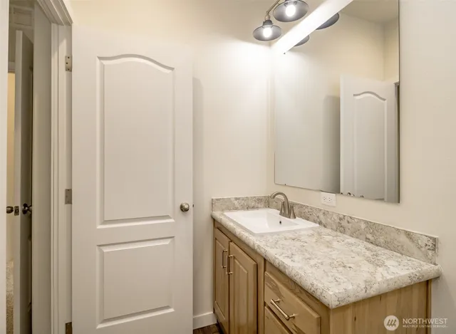 a bathroom with a granite countertop sink and a mirror