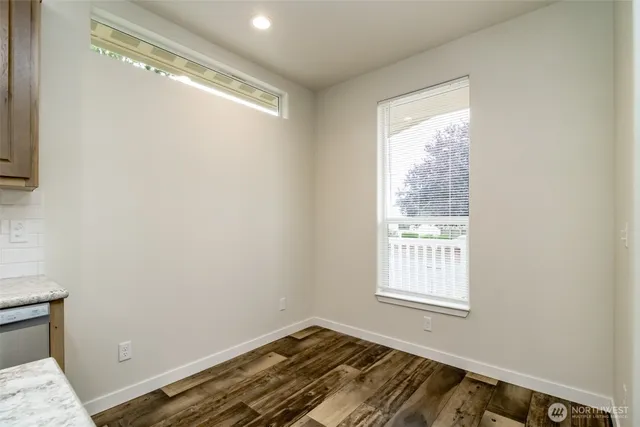 a view of a room with wooden floor and a window